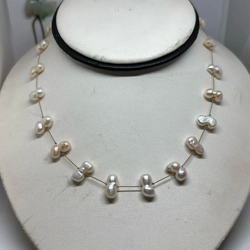 12mm culture freshwater pearl tin cup necklace. Made with beige silk cord